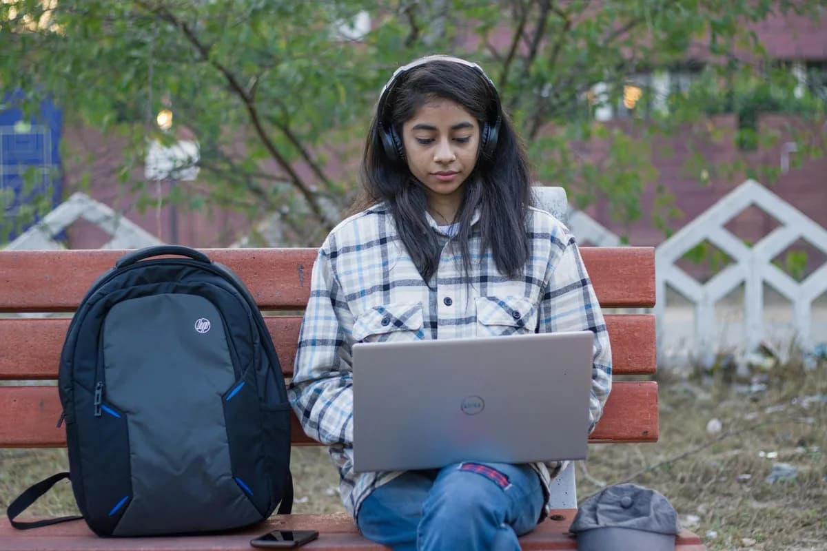 Indian business intelligence analyst monitoring live executive KPI reporting dashboards on laptop